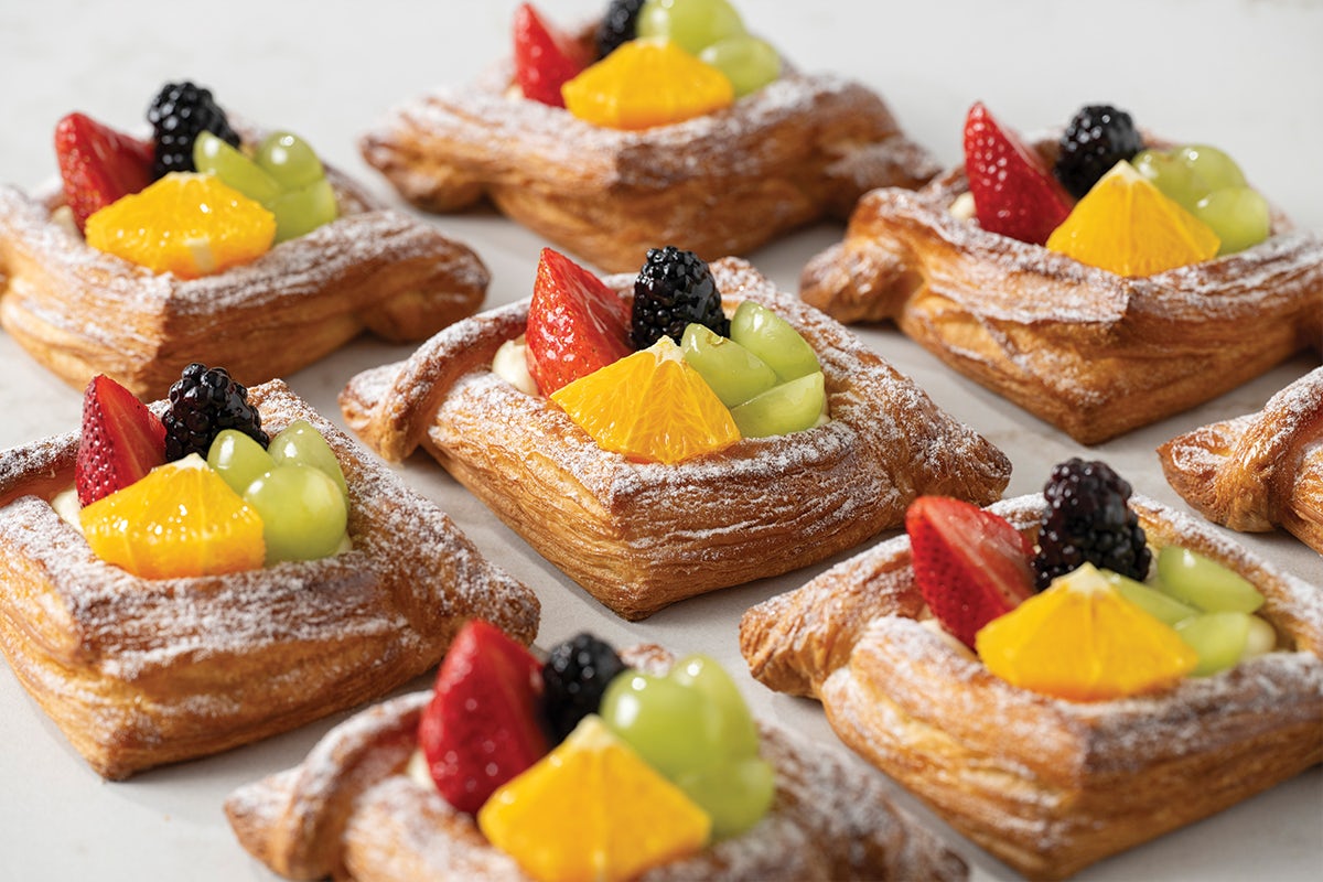 Group of Fruit Pastries Topped with Grapes, Blackberries, Strawberries, and Orange